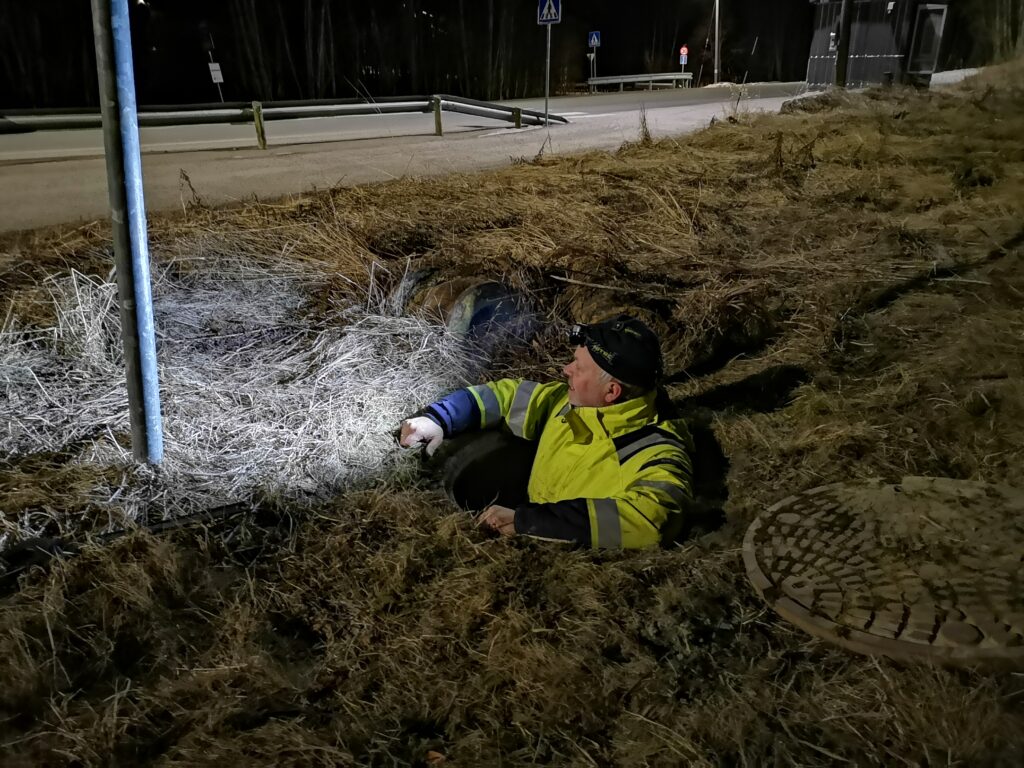 Bilde: Mann kommer opp av kum i vegen